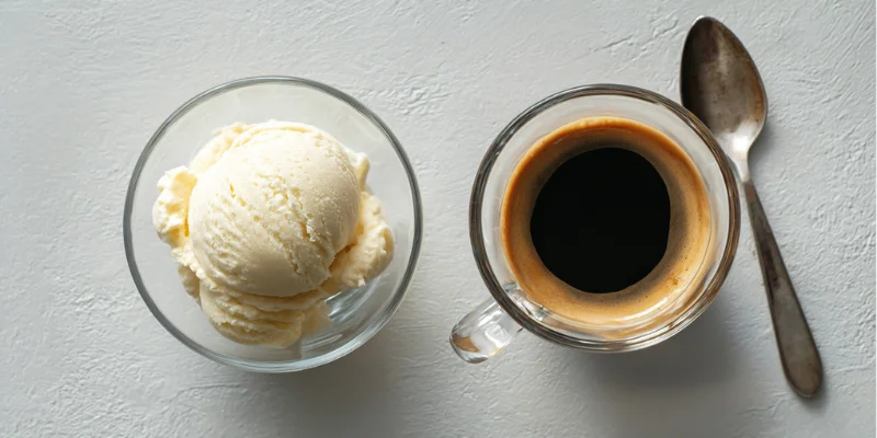 Vanilla ice cream scoop next to a small cup of hot espresso for an affogato recipe.

