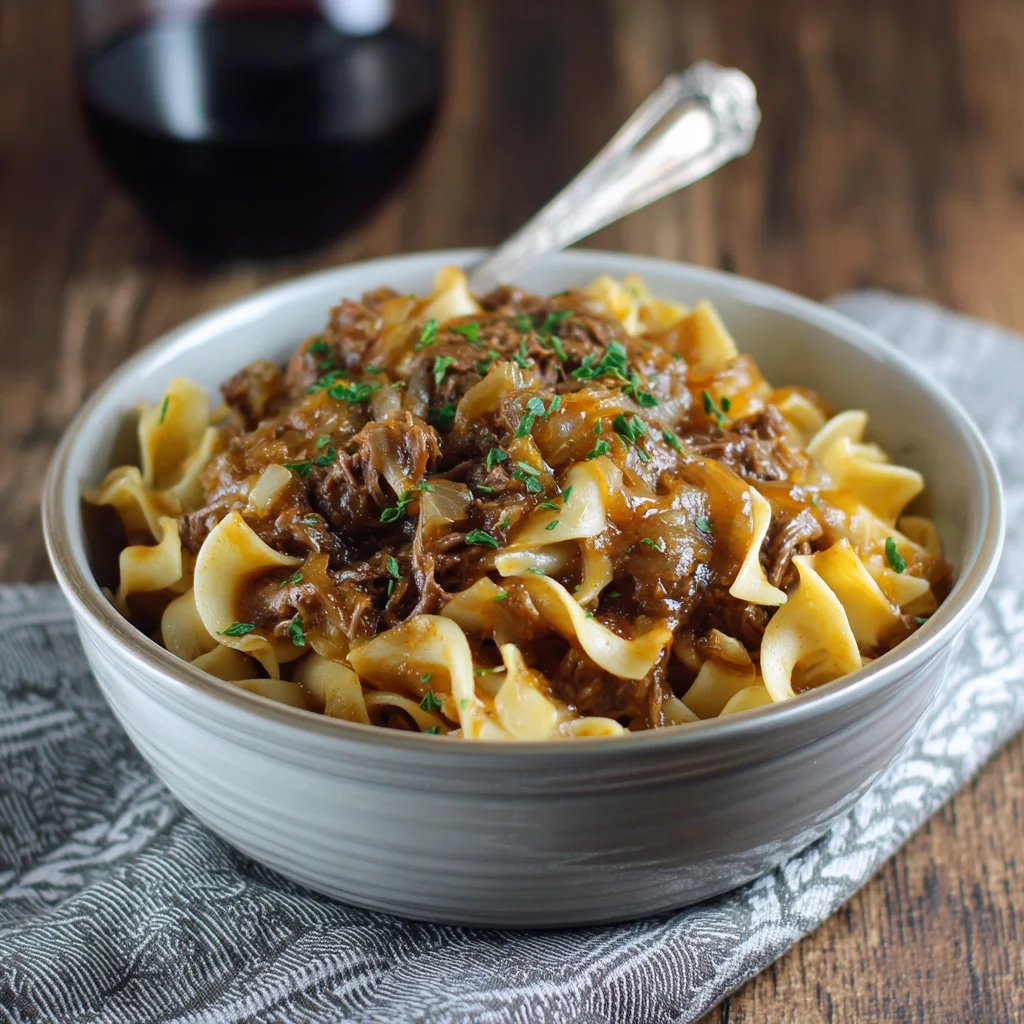 Finished French onion beef and noodles served in a bowl.