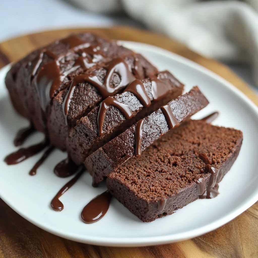 Moist keto chocolate pound cake sliced on a board.